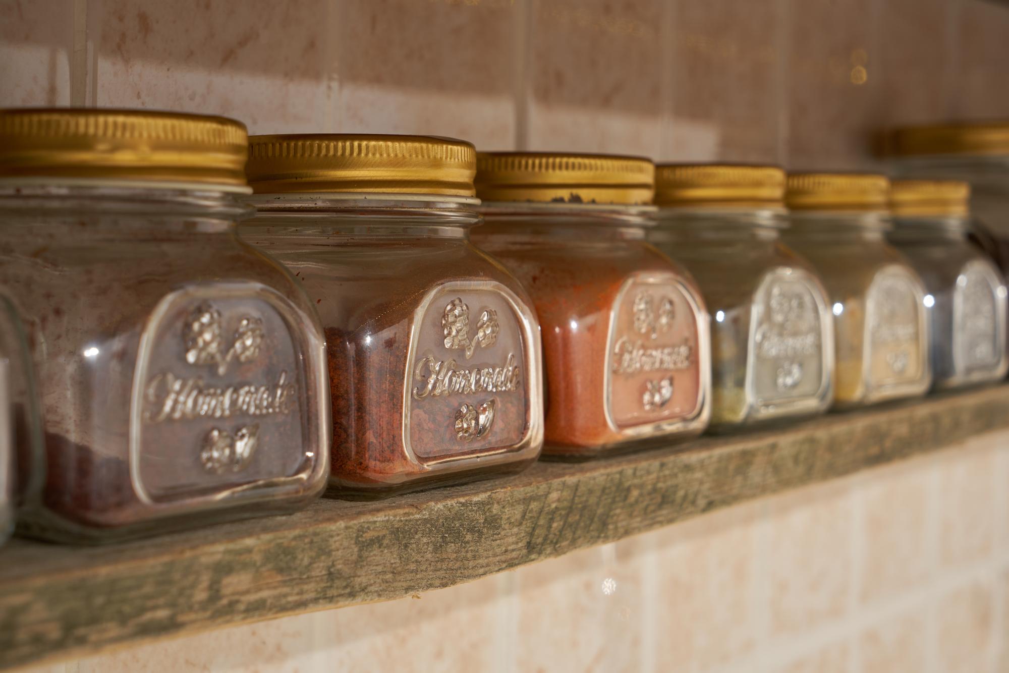 Workshop counter with jars of preserved vegetables and labeled tins